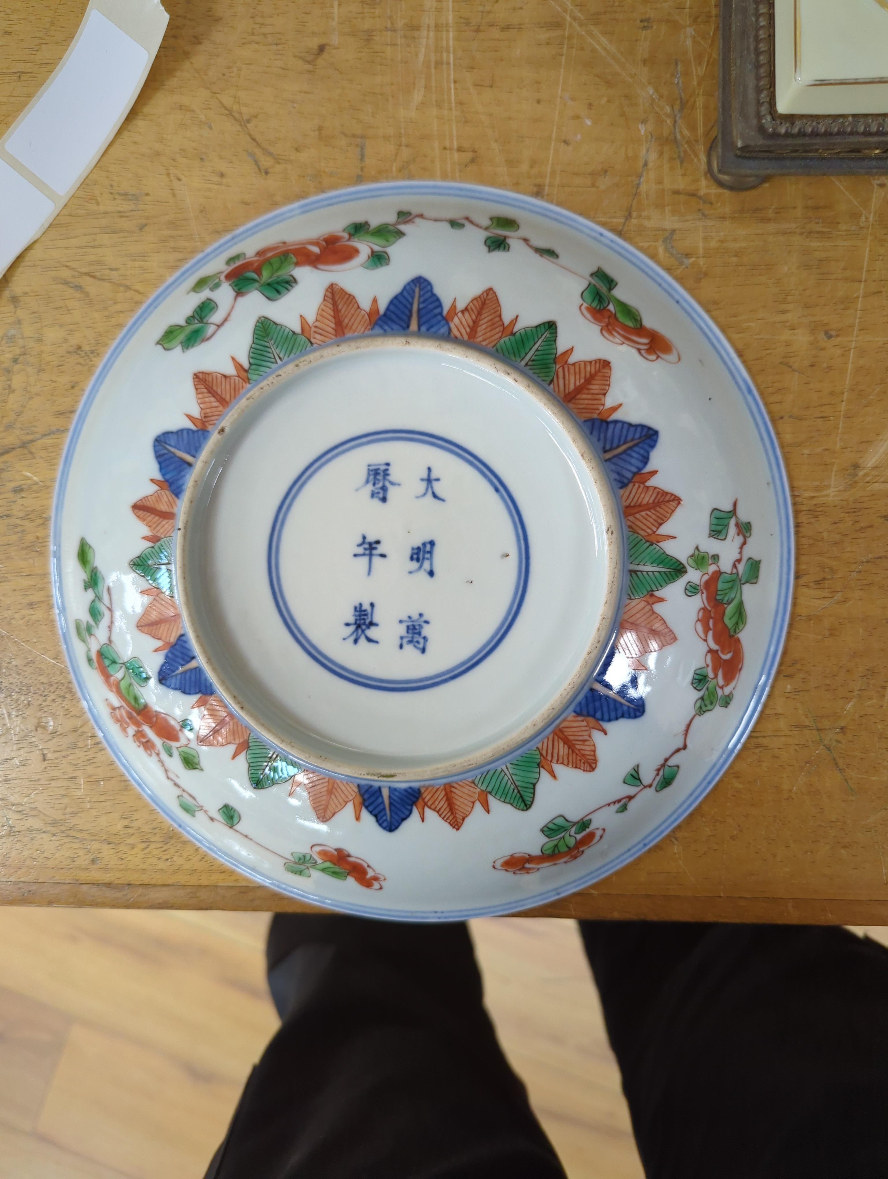 An 18th century Chinese famille rose bowl and a group of five Chinese wucai plates, each decorated with fruit, the bowl 23cm in diameter